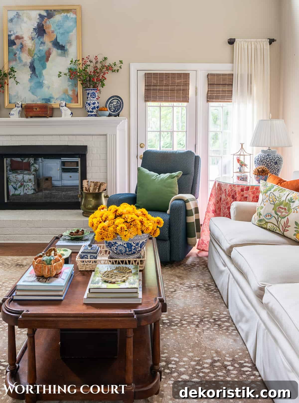 side view of beige sofa and blue chair beside white brick fireplace with fall decorations