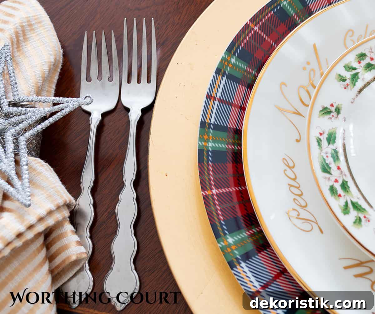 Christmas place setting with Christmas china plates stacked with tartan plaid plates on a gold charger