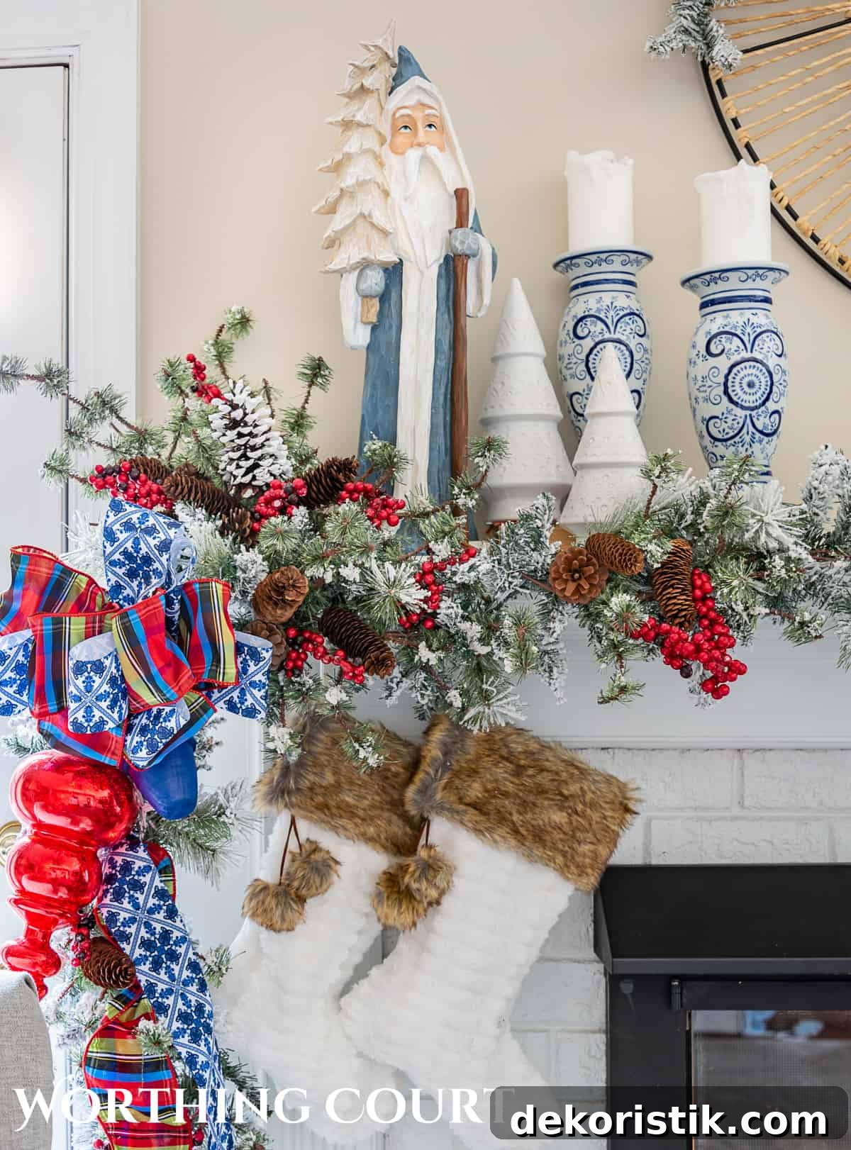 one end of a fireplace mantel with Christmas garland, ornaments and ribbon with a pair of fur topped stockings