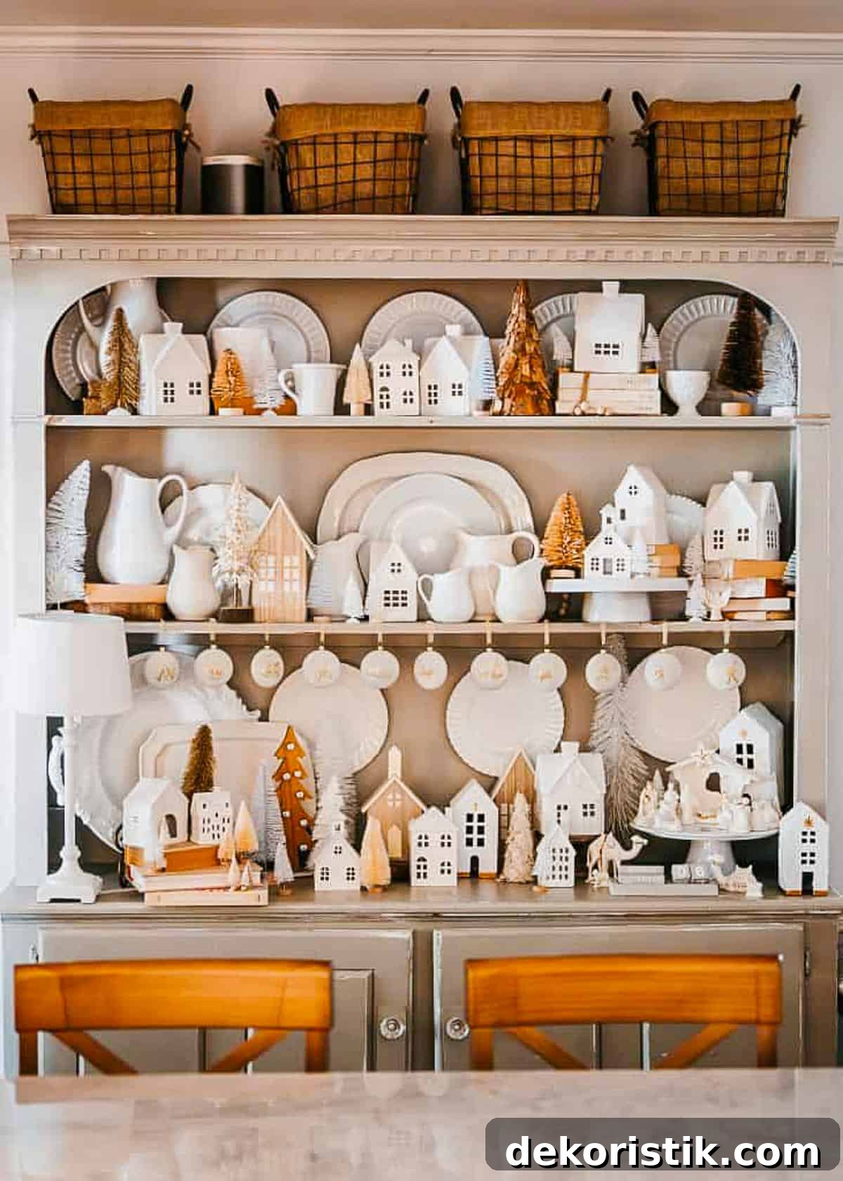 small nativity scene in a large hutch filled with white stoneware and dishes
