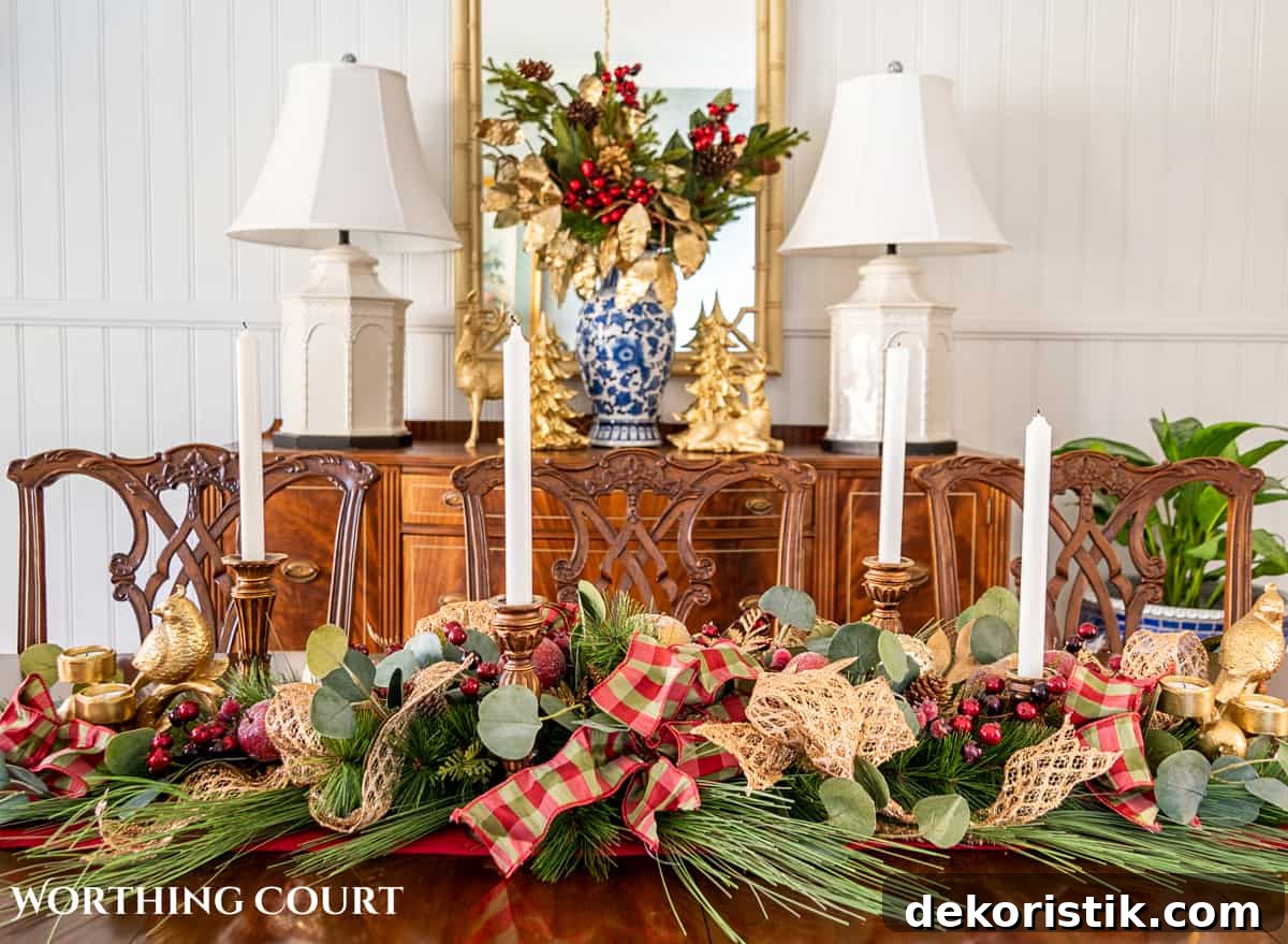 Christmas centerpiece on a wood dining room table made with burgundy, green and gold elements.