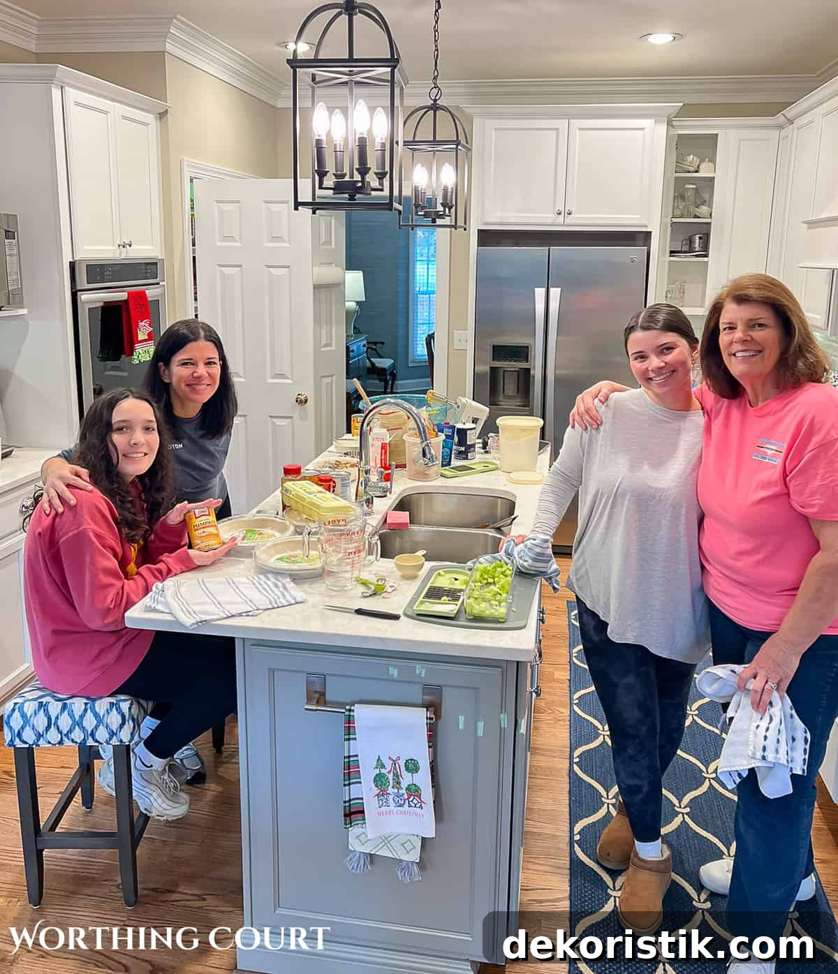 4 women standing around an island in a kitchen with white cabinets