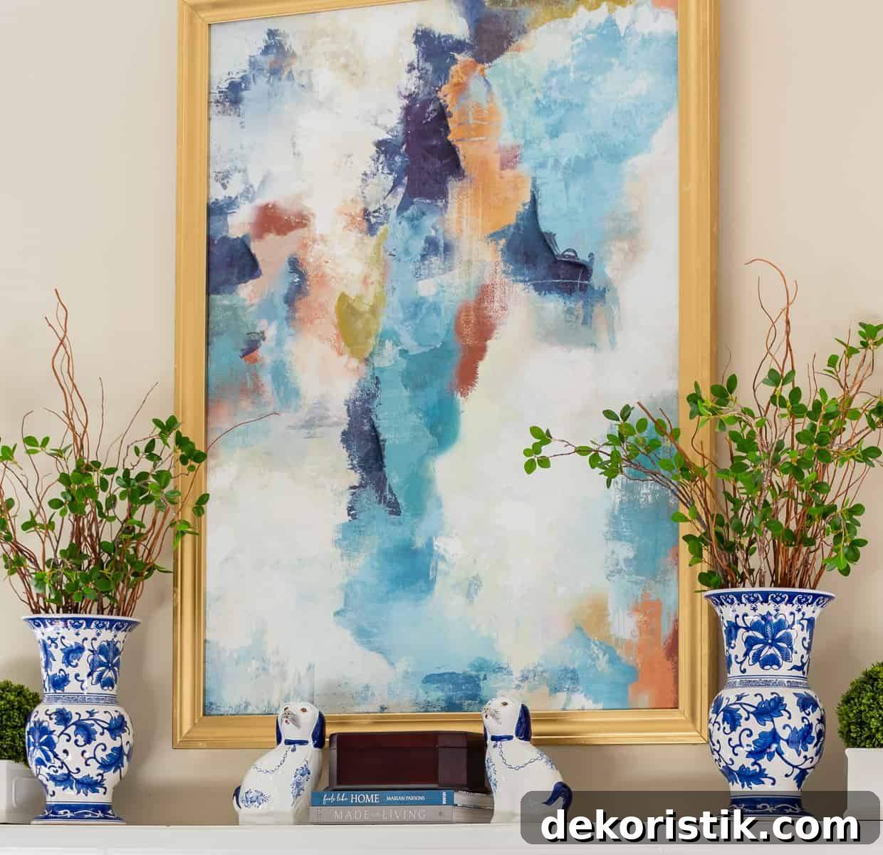 mantel with abstract art above and blue and white vases filled with stems on each end for winter decor