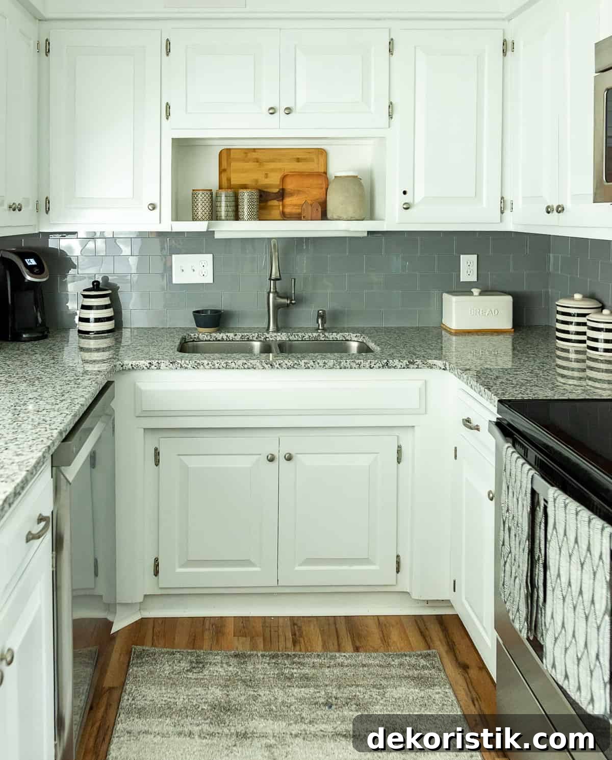 U shaped kitchen with white cabinets and granite counters