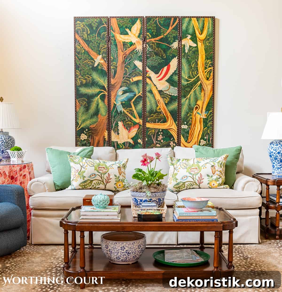 tan couch against a wall with a decorative screen hung above it and a decorated coffee table in front