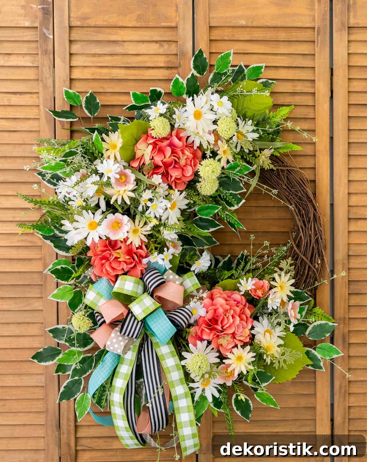 assortment of brightly colored flowers and ribbon on a grapevine wreath for spring