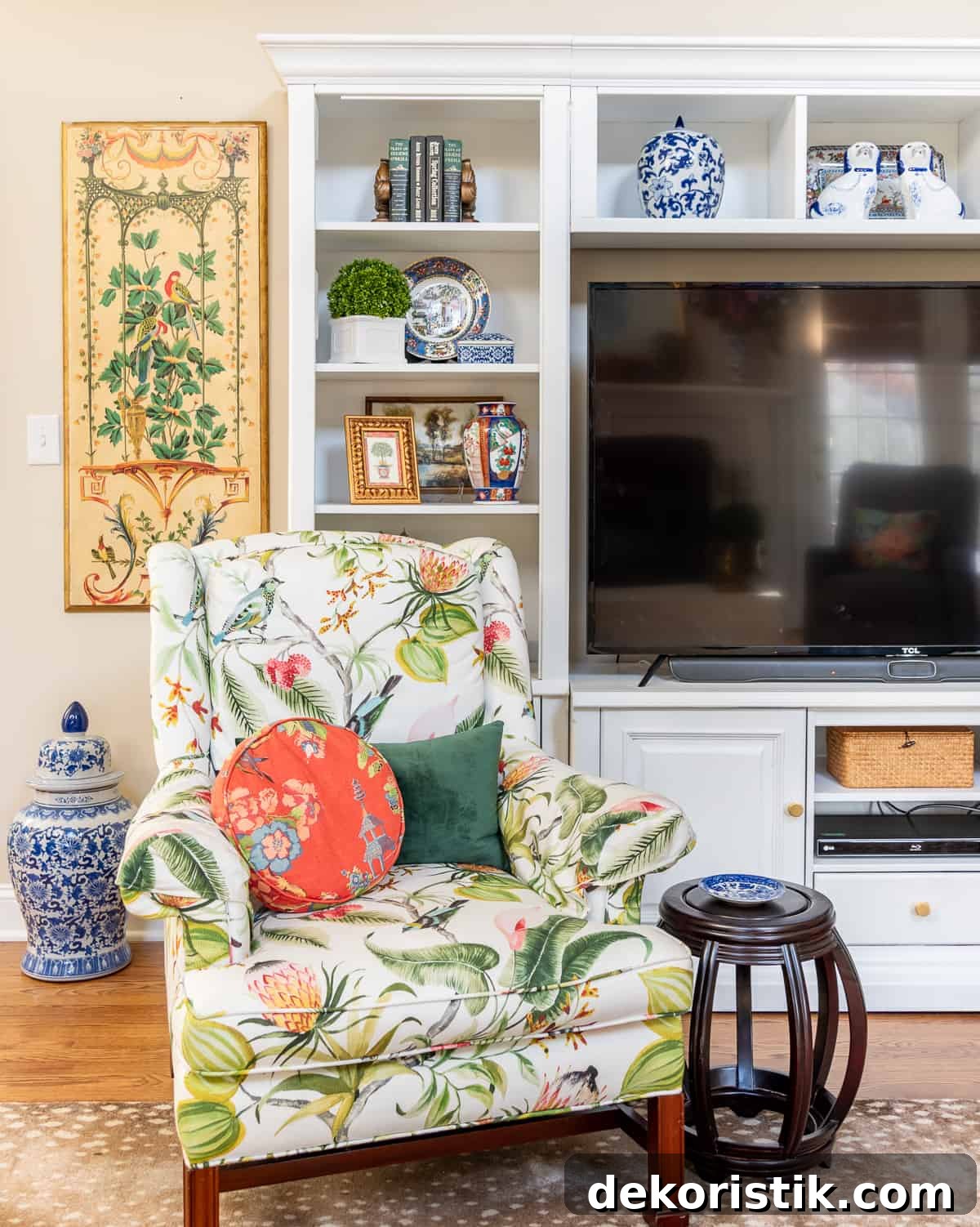 living room decorated for spring with colorful accessories in a white entertainment center with two colorful chairs in front