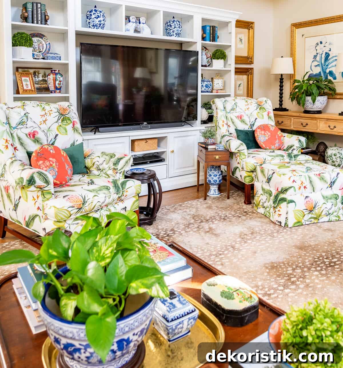 living room decorated for spring with colorful accessories in a white entertainment center with two colorful chairs in front