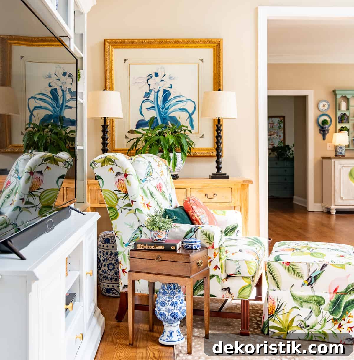 living room decorated for spring with colorful accessories in a white entertainment center with two colorful chairs in front