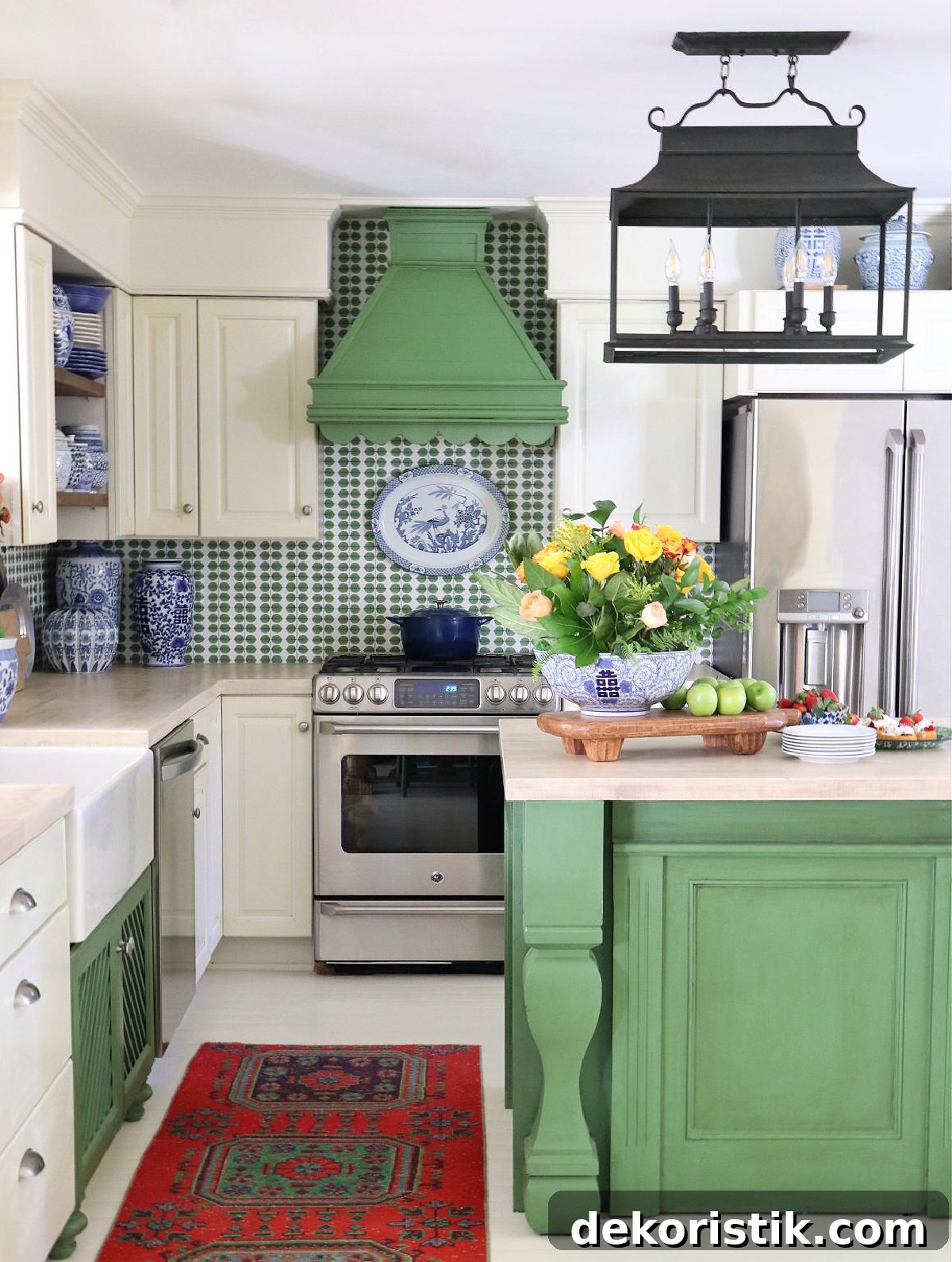 kitchen with white cabinets, a green island, a green hood with scalloped edge and green and white wallpaper backsplash