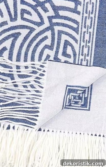 corner of a blue and white light weight throw blanket with tassels