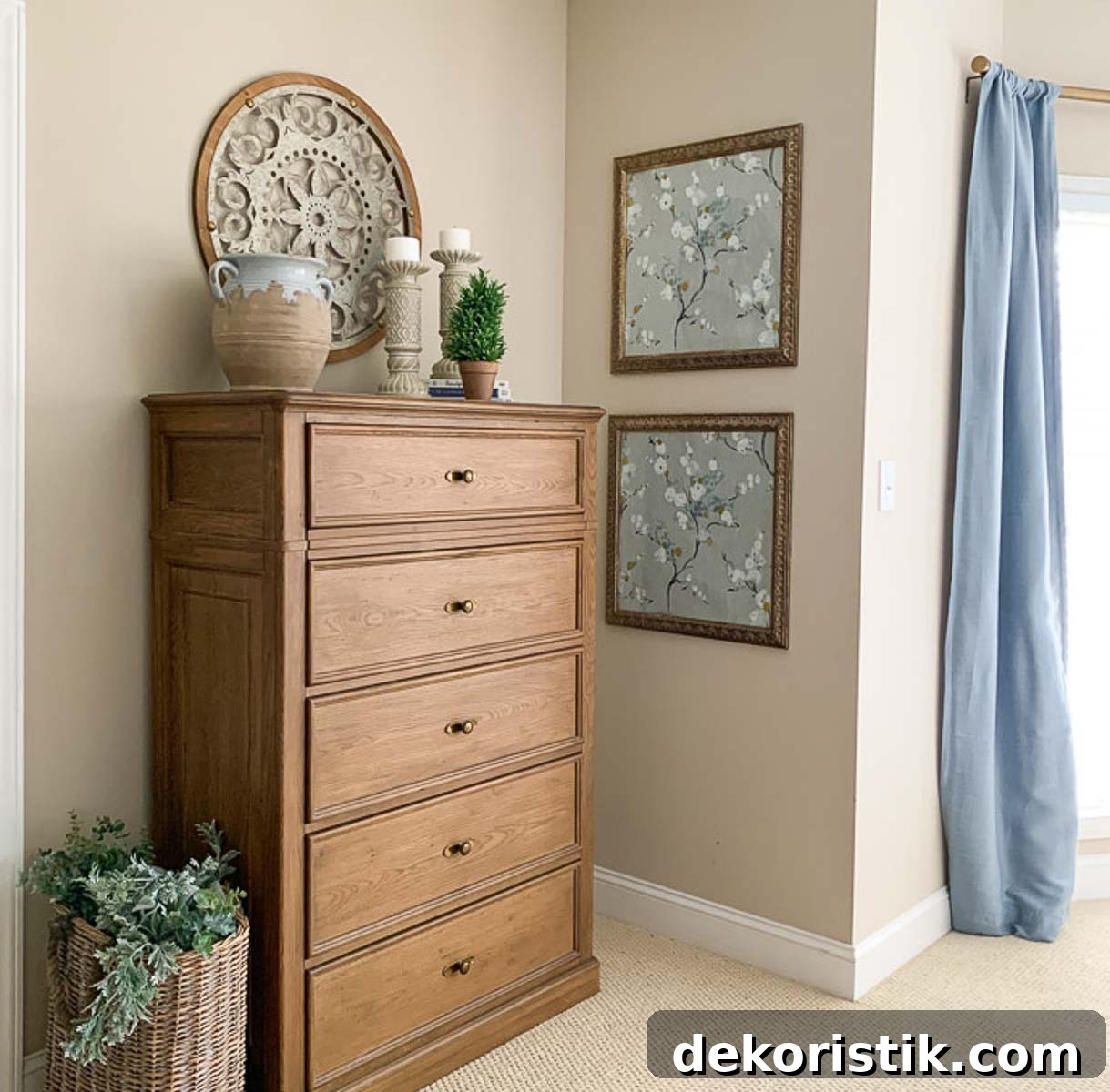 brown dresser in a bedroom with beige walls and blue curtains