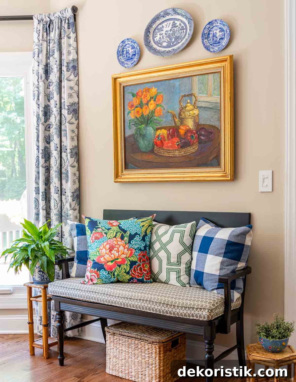 black bench with colorful summer pillows below an original oil painting