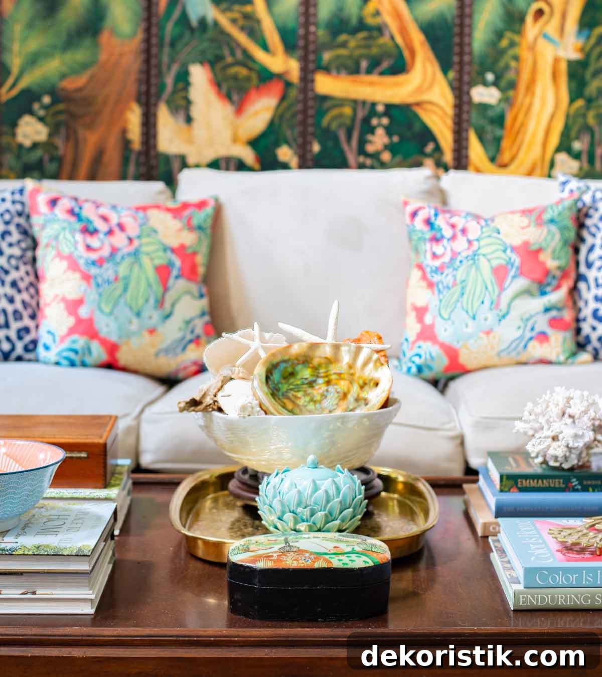 floral throw pillows on a neutral sofa with a wood coffee table in front with traditional summer accessories