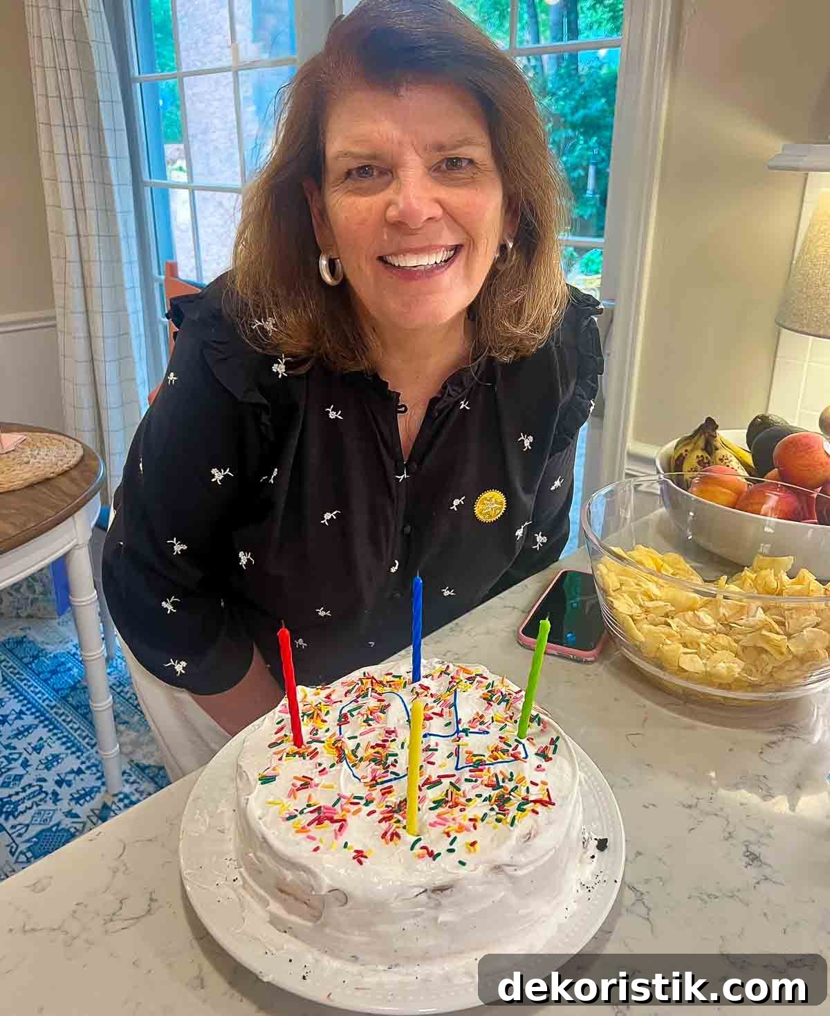 woman leaning over a birthday cake with candles