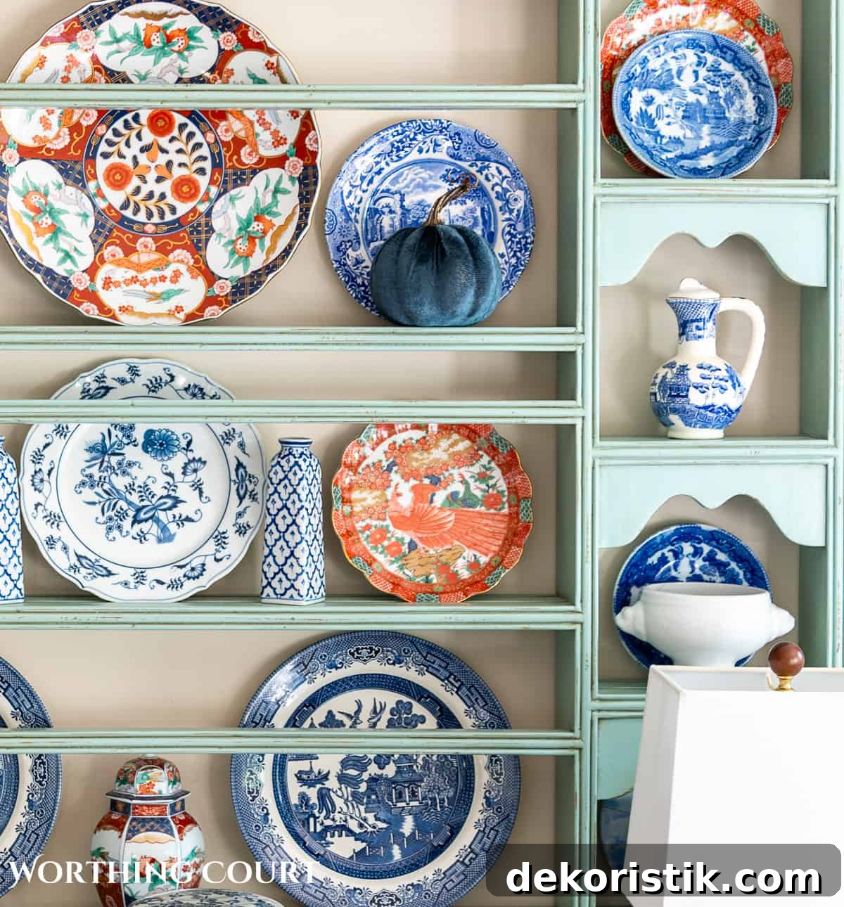 plate rack above a white sideboard filled with blue and white dishes and orange dishes for fall