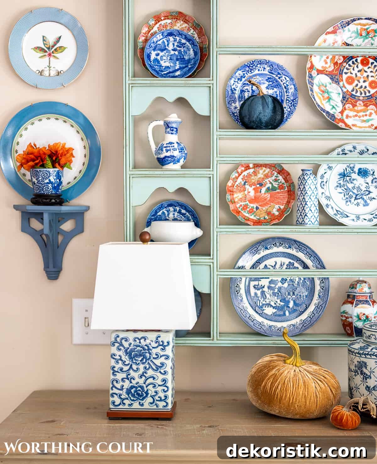 plate rack above a white sideboard filled with blue and white dishes and orange dishes for fall