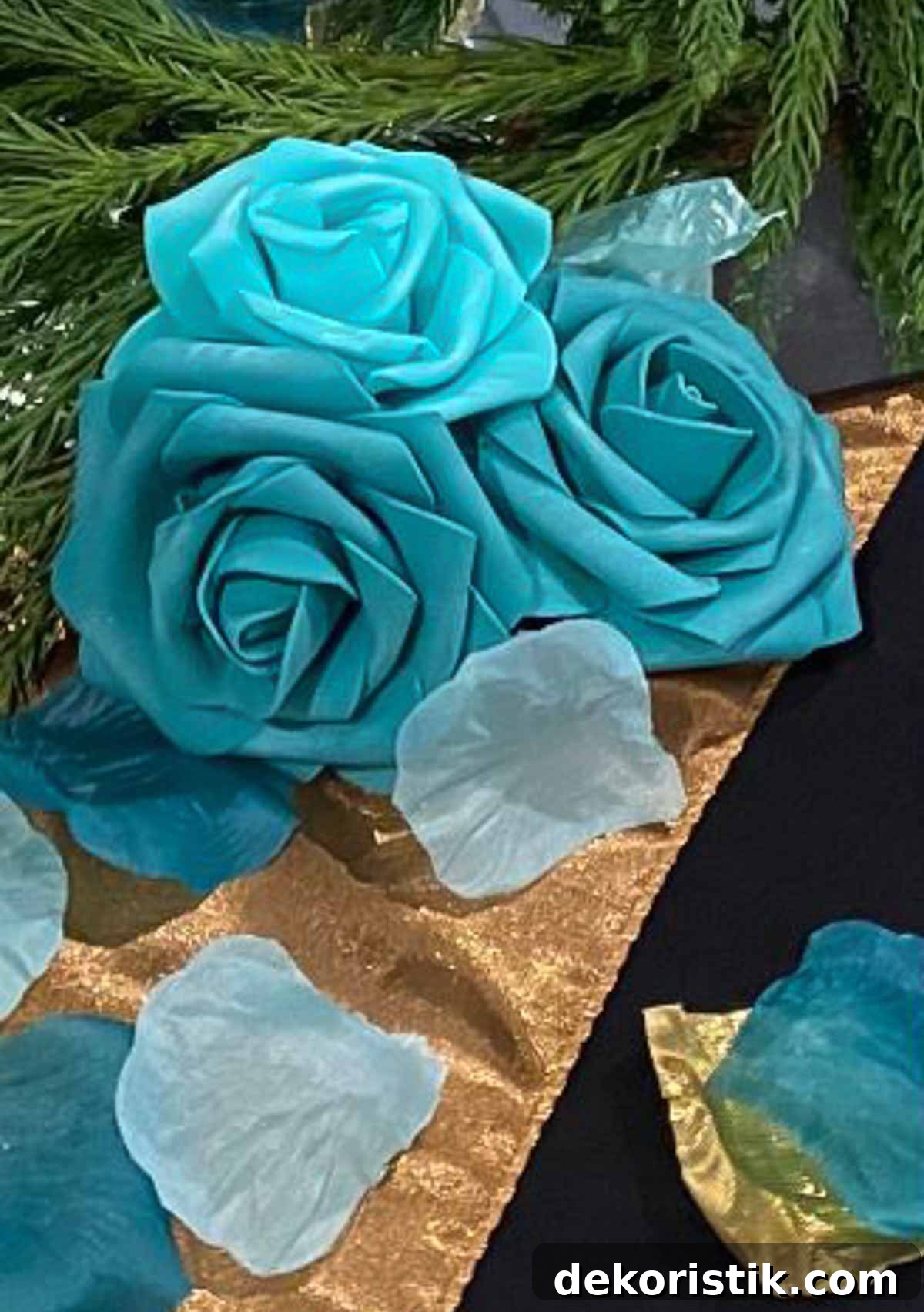trio of turquoise roses on a gold table runner on a black tablecloth