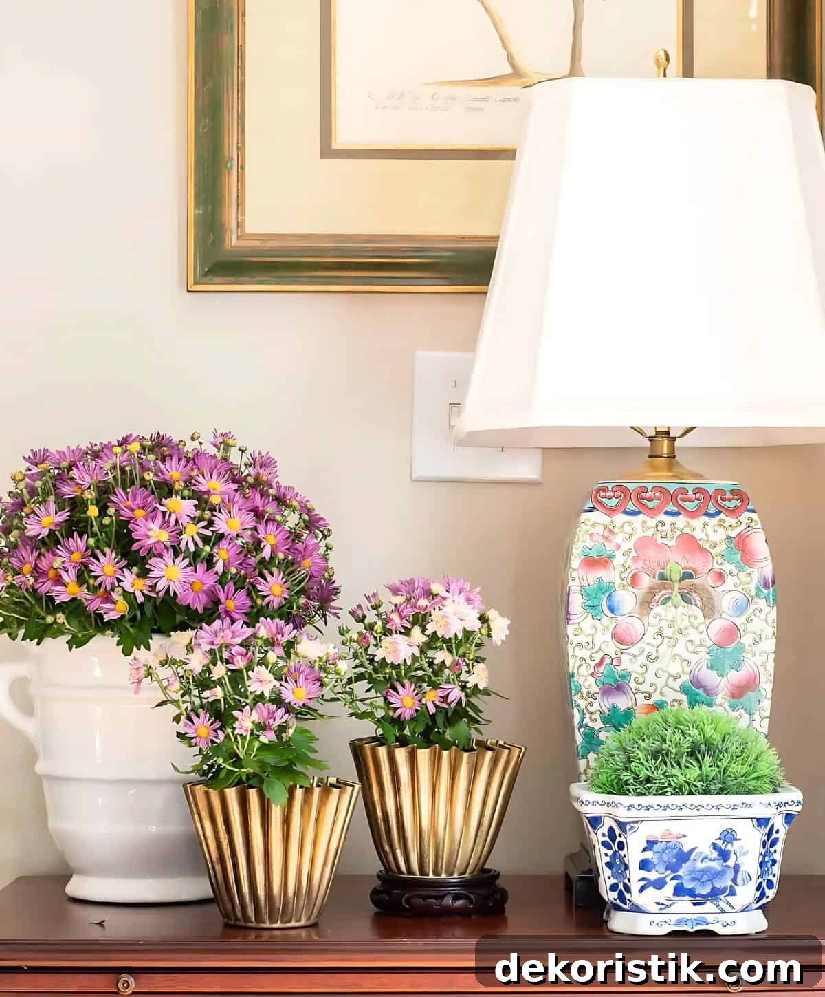 three purple mums in various containers on a wooden chest