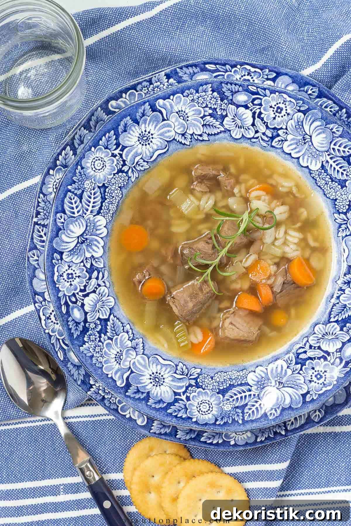 beef barley soup in a blue and white rimmed soup bowl