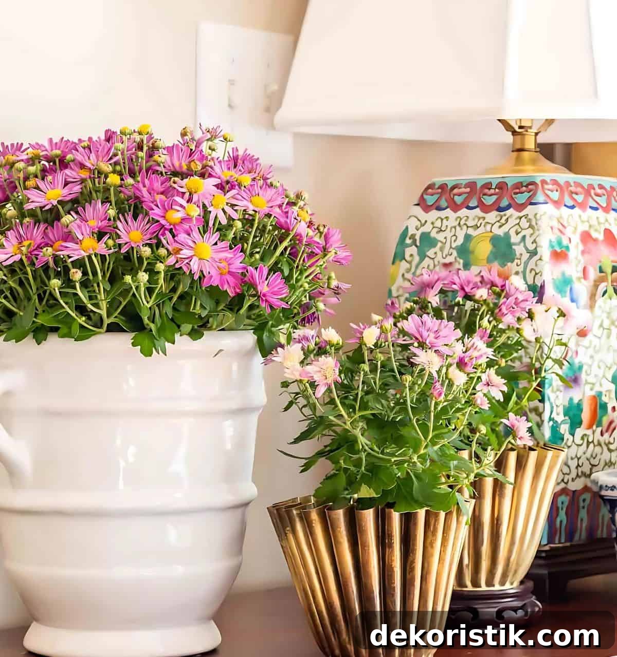 three purple mums in various containers on a wooden chest