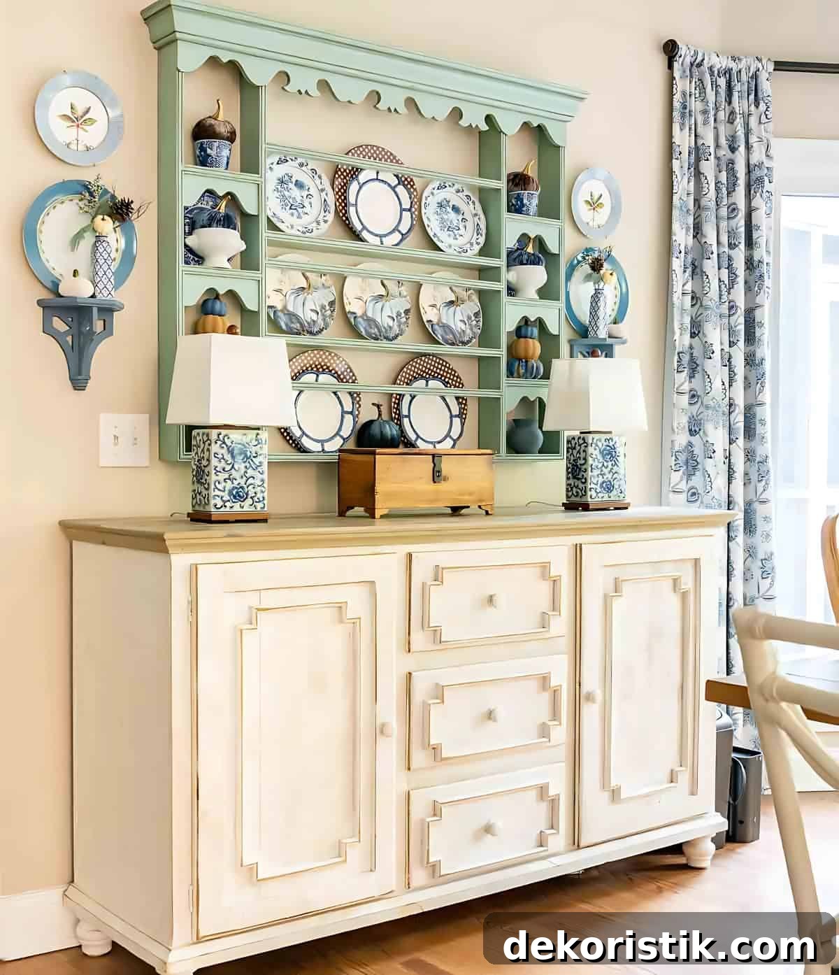 blue, white and brown dishes displayed on a plate rack for fall hanging above a white sideboard