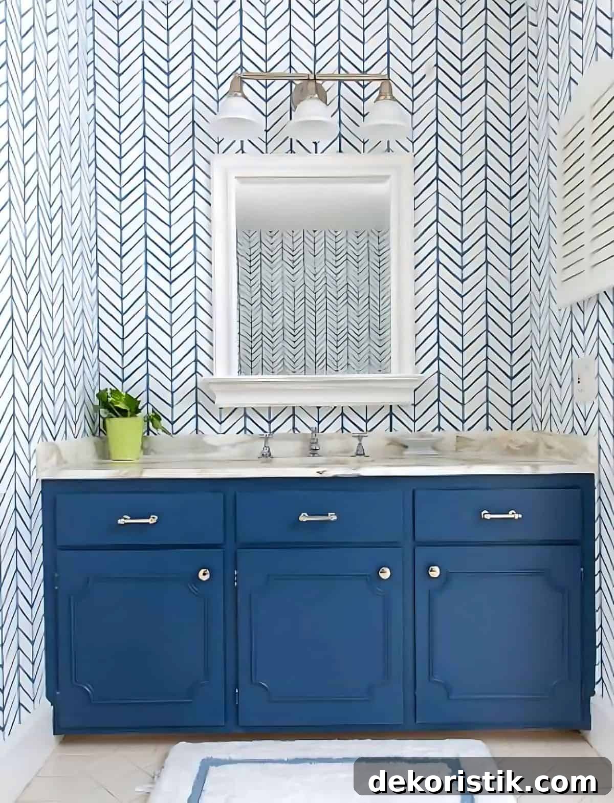 blue bathroom vanity in front of blue and white geometric wallpaper