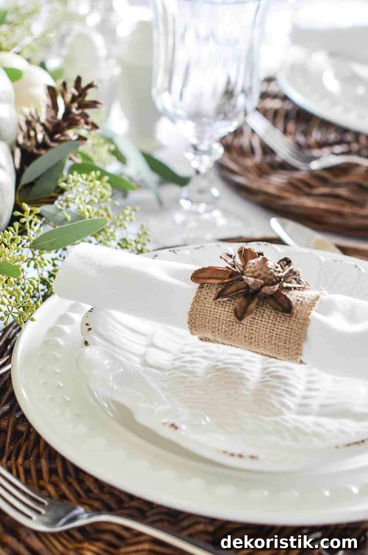 place setting with white dishes and a white napkin with a burlap napkin ring
