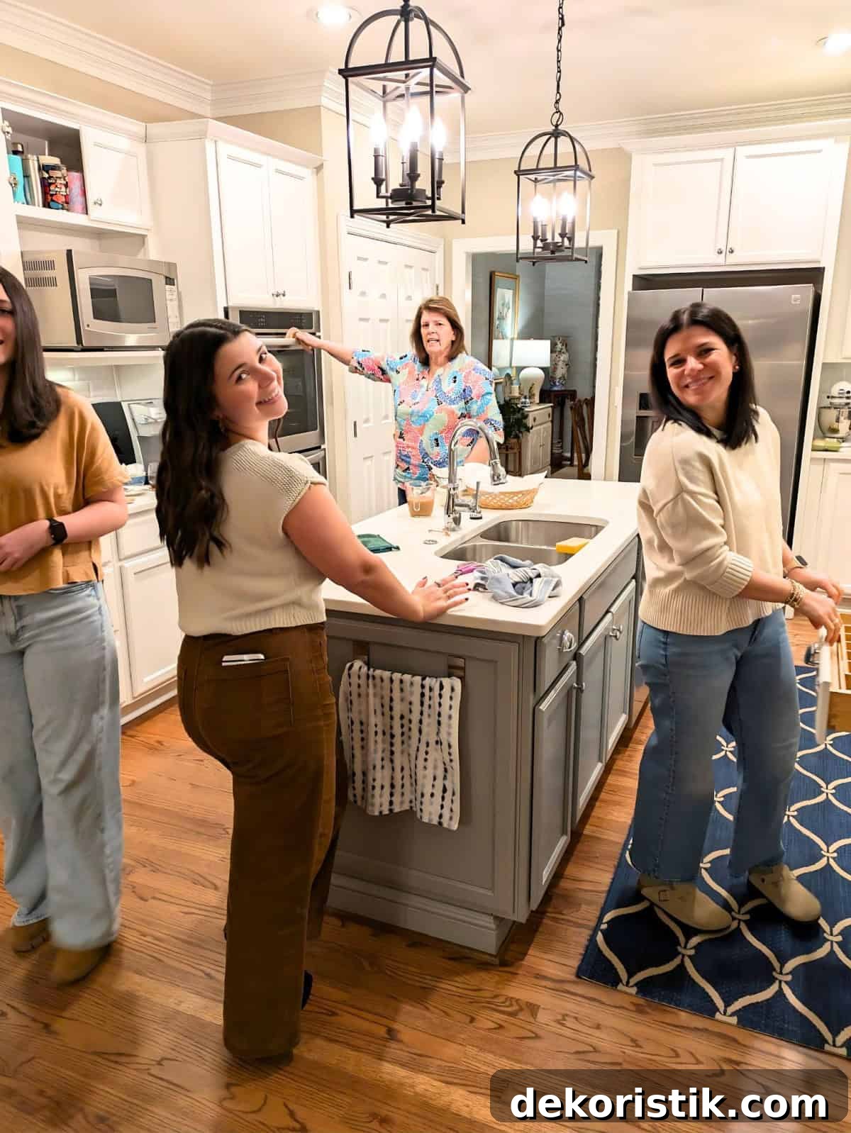 4 women cooking in a kitchen with white cabinets