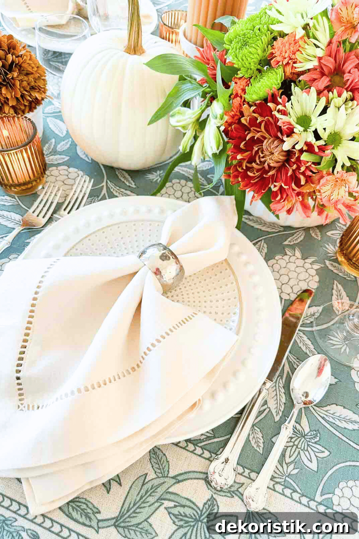 white thanksgiving place setting on a blue floral tablecloth