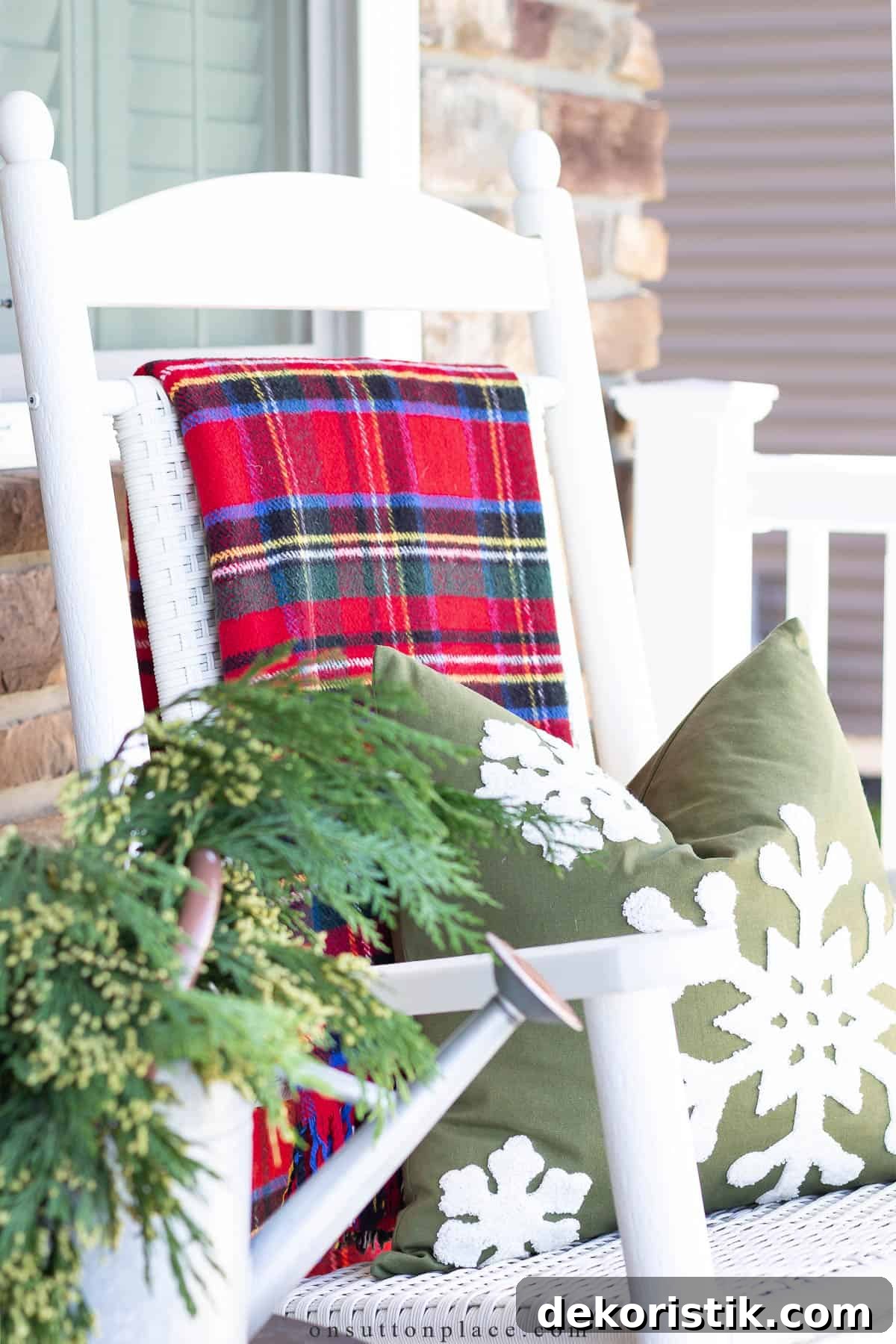 white rocking chair with a tartan plaid blanket over the back
