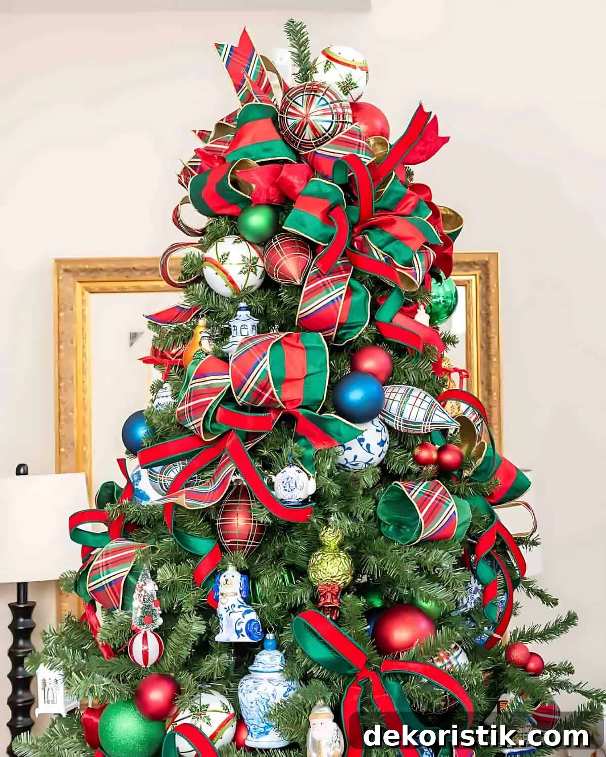 Chinoiserie Christmas tree decorated with red and green ornaments and blue and white Chinoiserie ornaments and tartan plaid ribbon