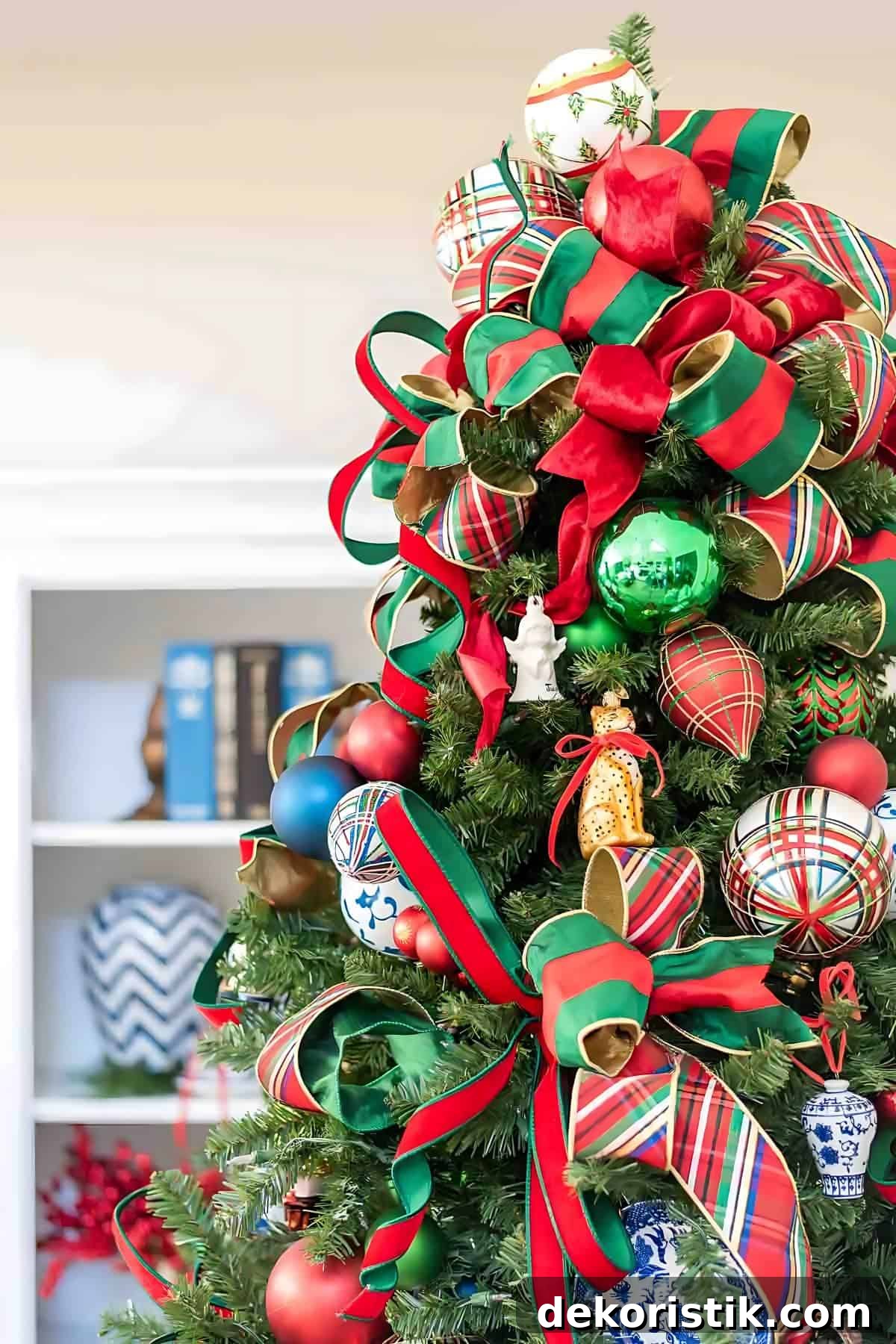 Chinoiserie Christmas tree decorated with red and green ornaments and blue and white Chinoiserie ornaments and tartan plaid ribbon