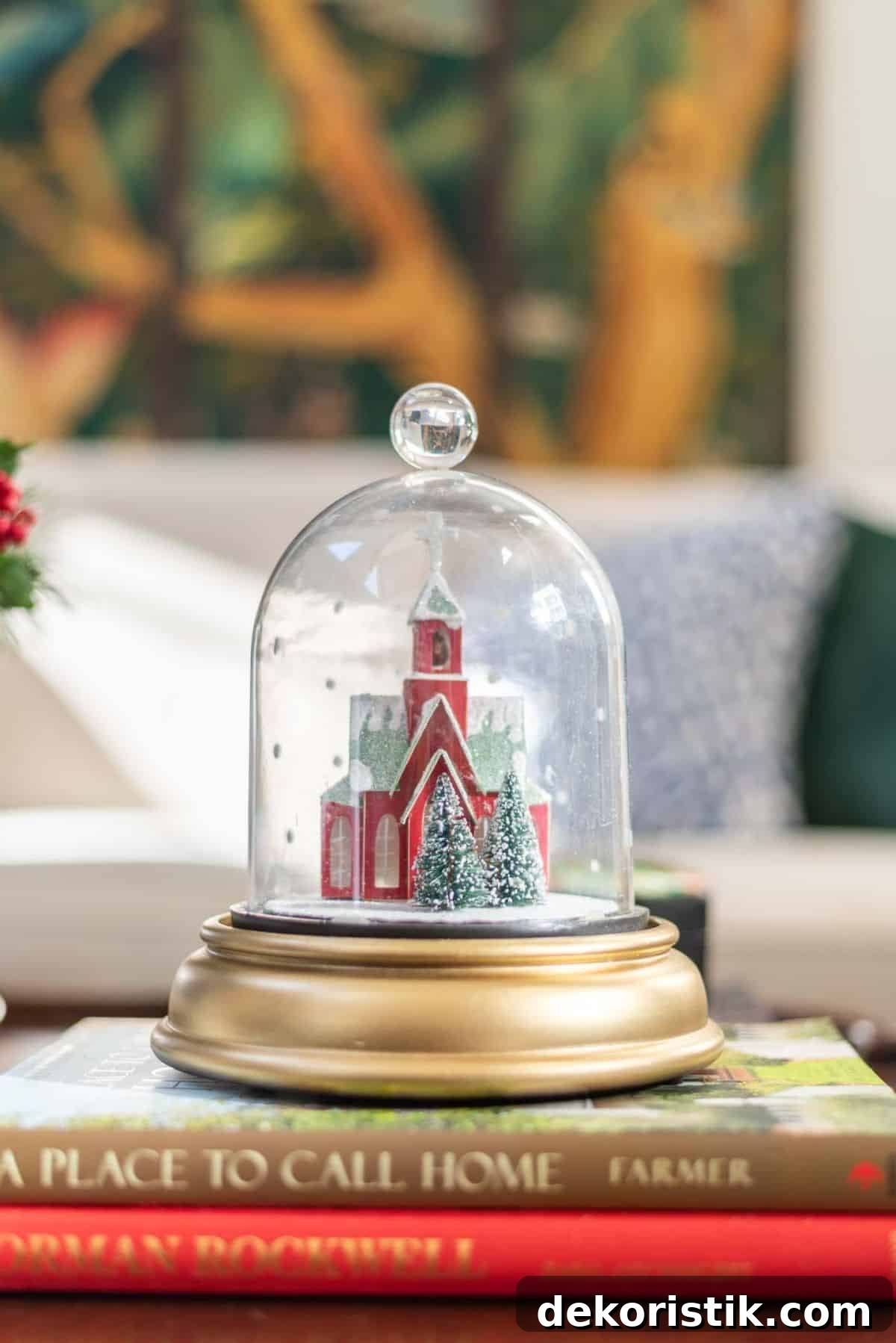 tiny red church under a glass cloche on a gold pedestal