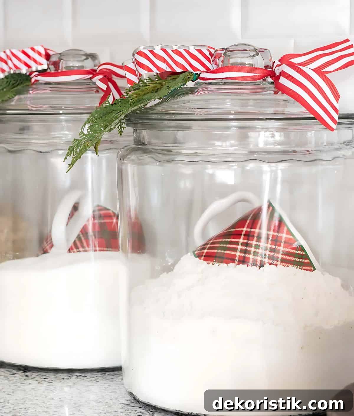 glass canisters filled with flour and sugar with Christmas mugs for scoops
