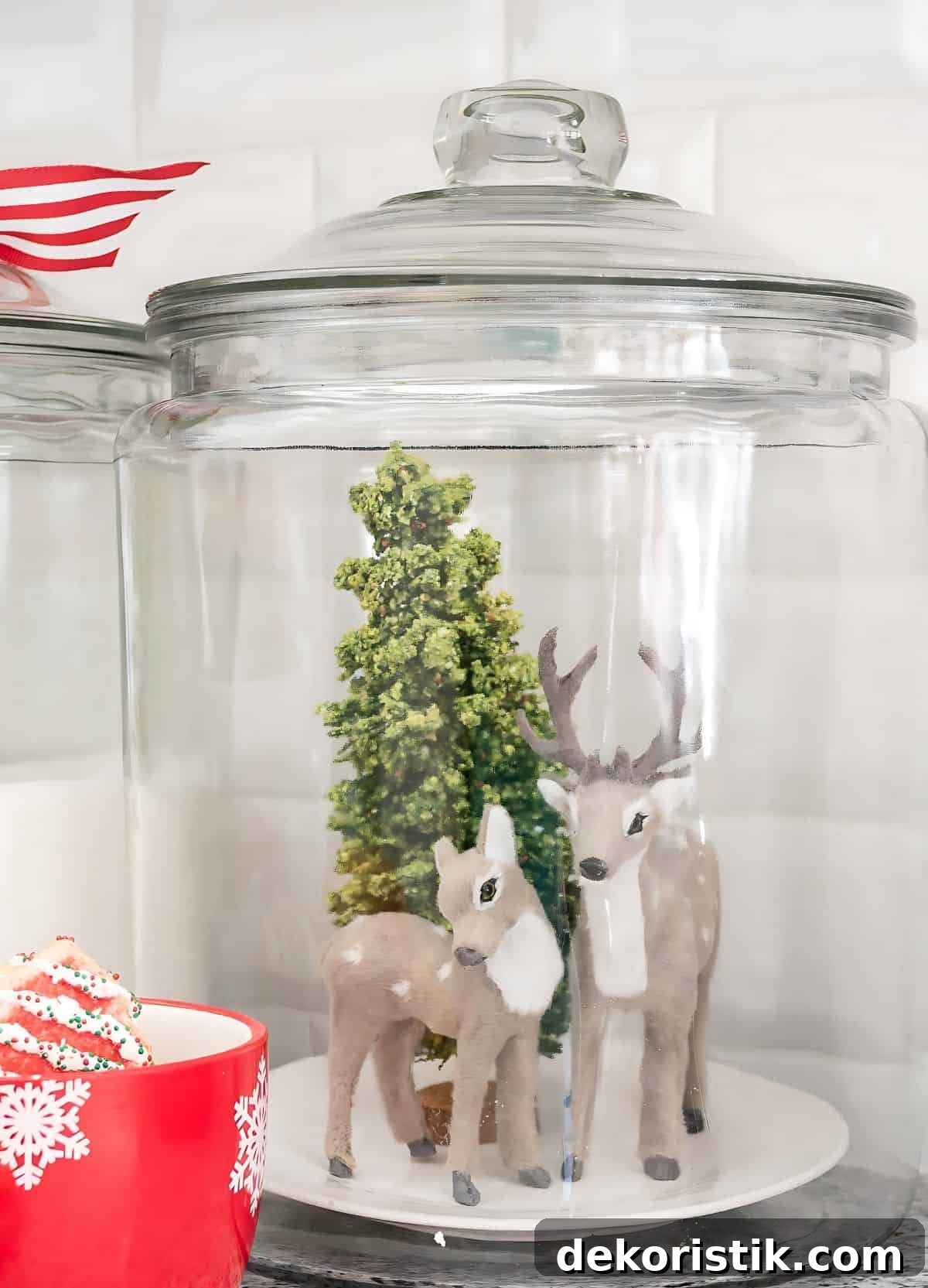 glass canister with two deer and mini Christmas tree inside