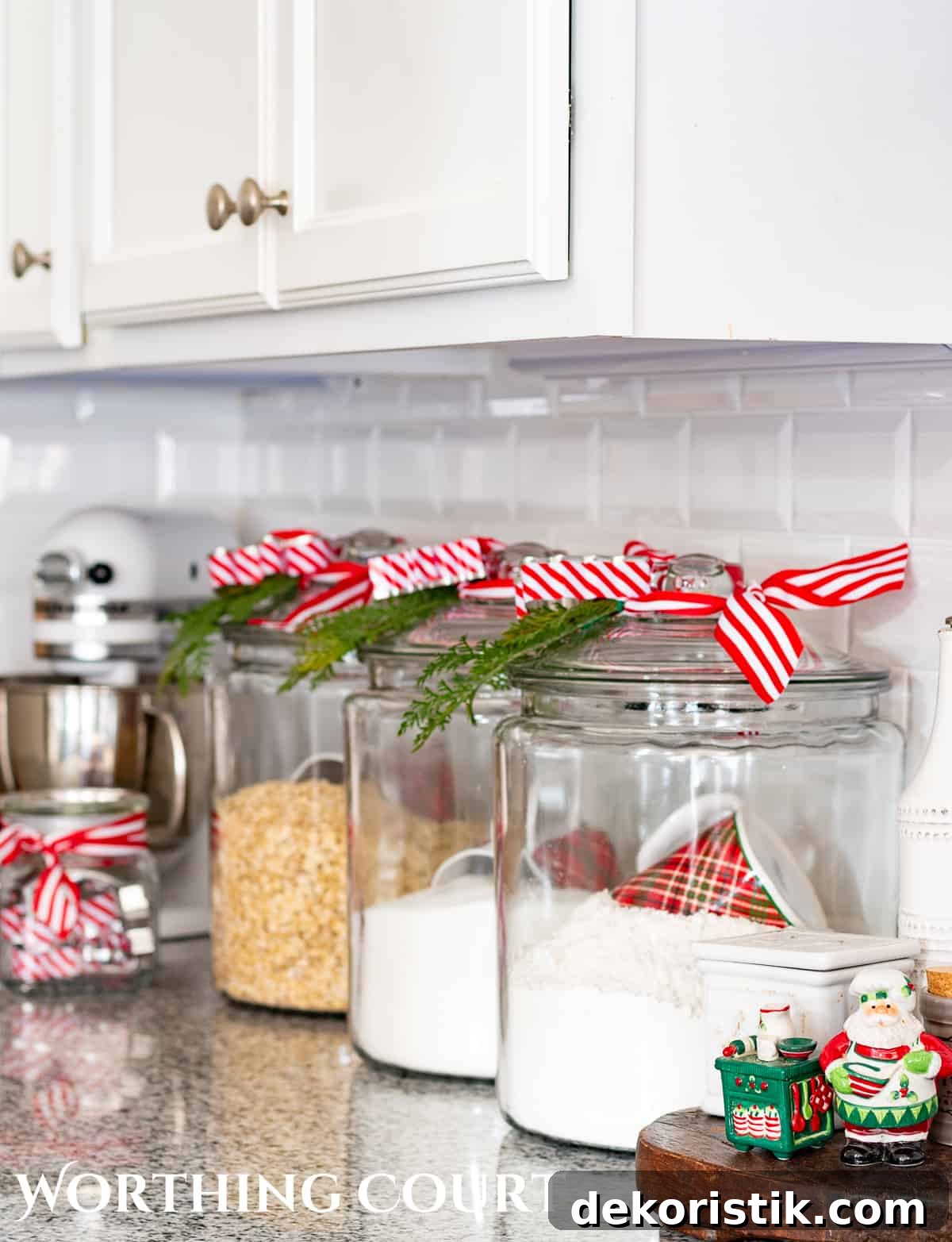 clear glass canisters with red and white striped ribbon an greenery bits tied to the tops