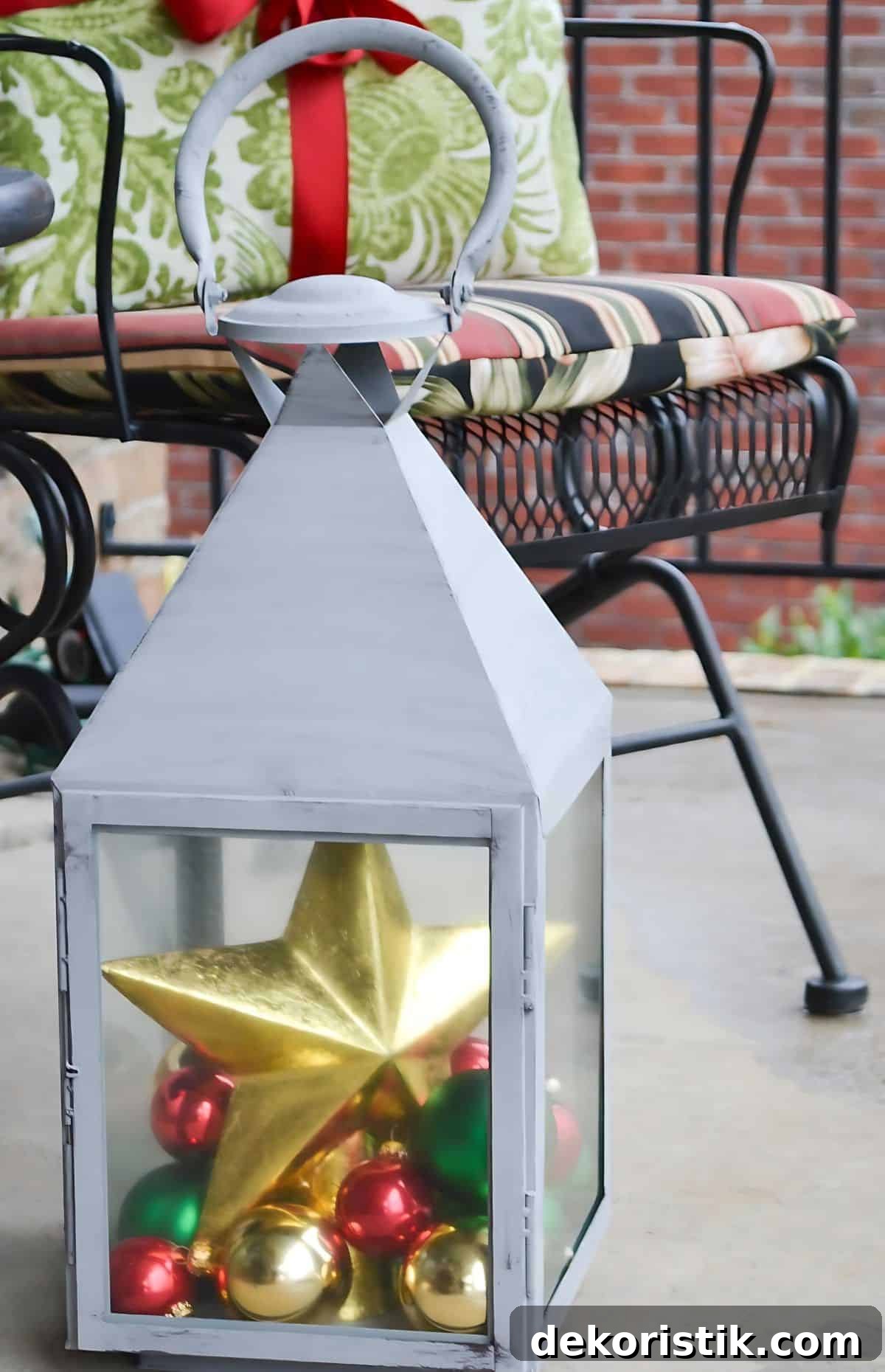 large lantern filled with ornaments and a tree topper star