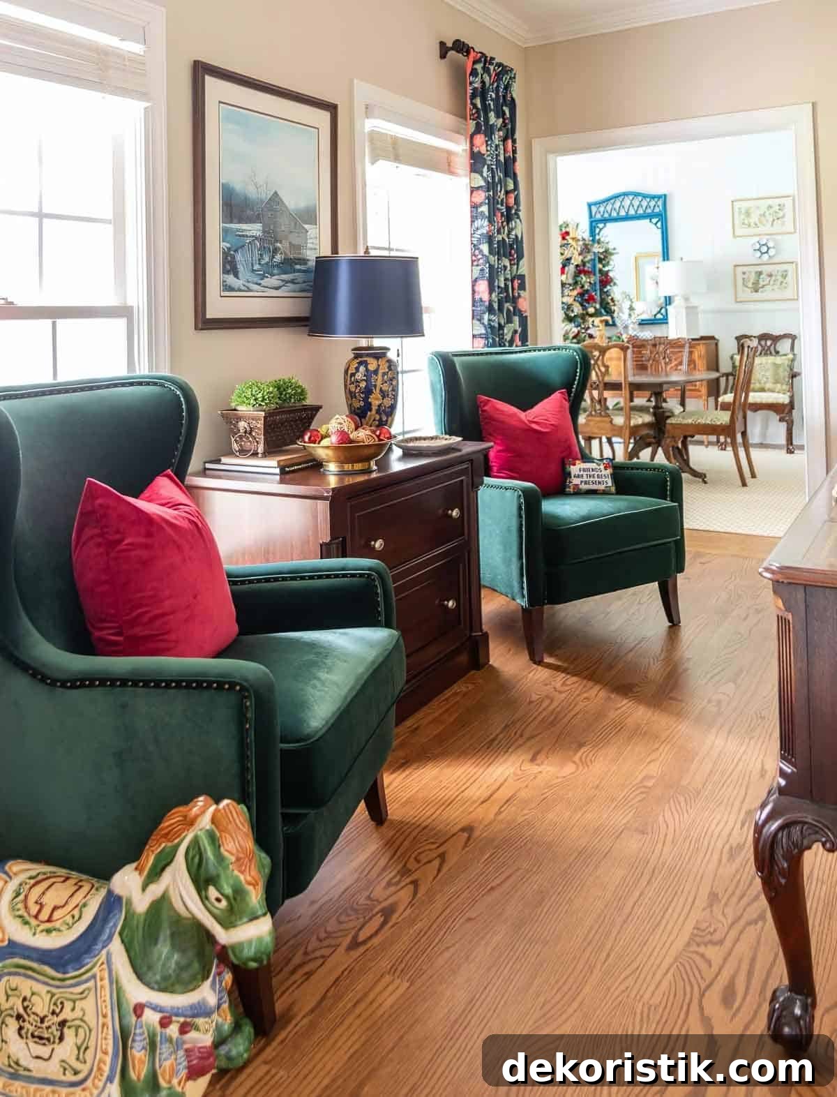 pair of green velvet chairs flanking a wood lateral file cabinet