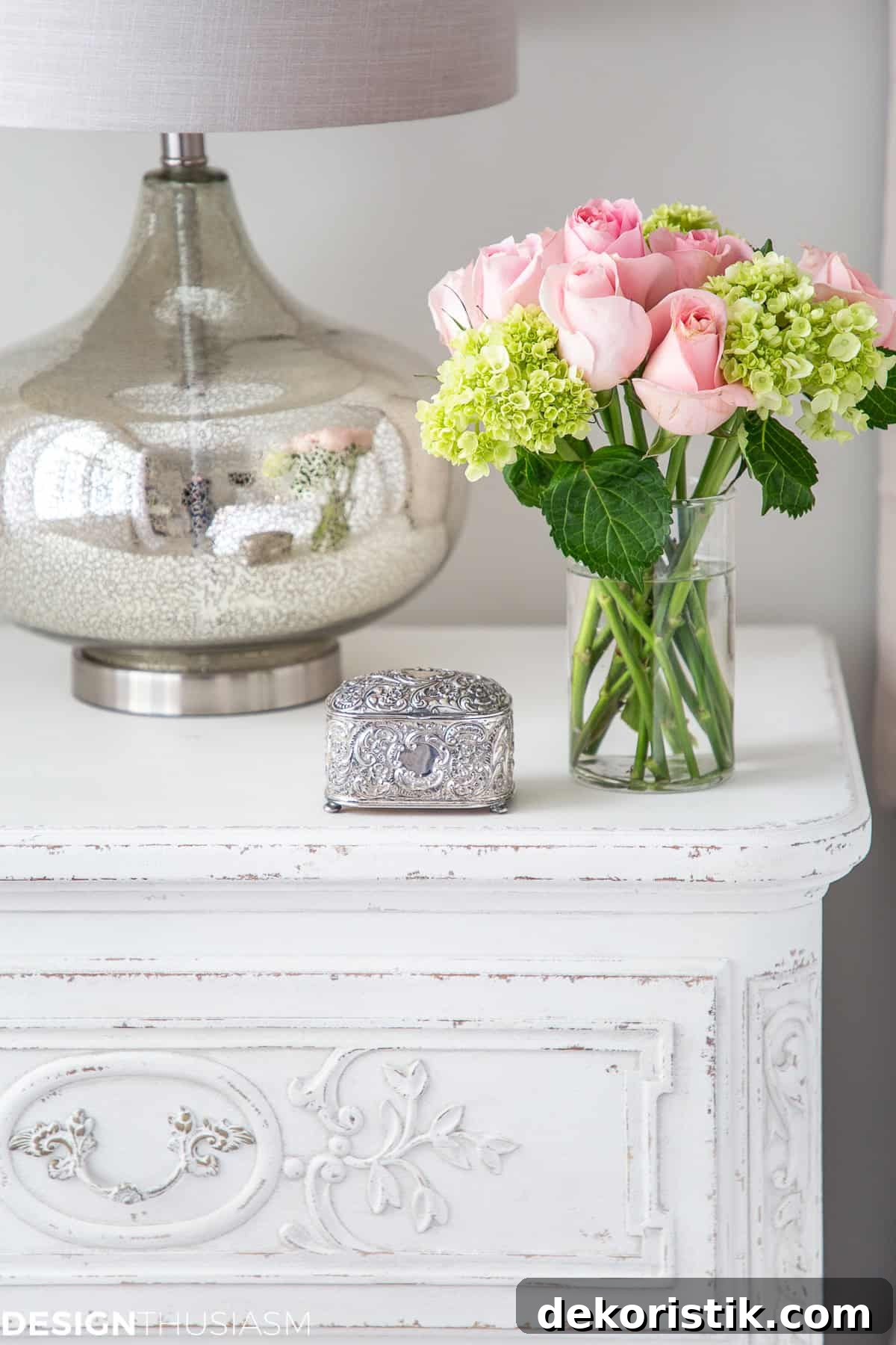 flower arrangement in a glass vase on a white end table