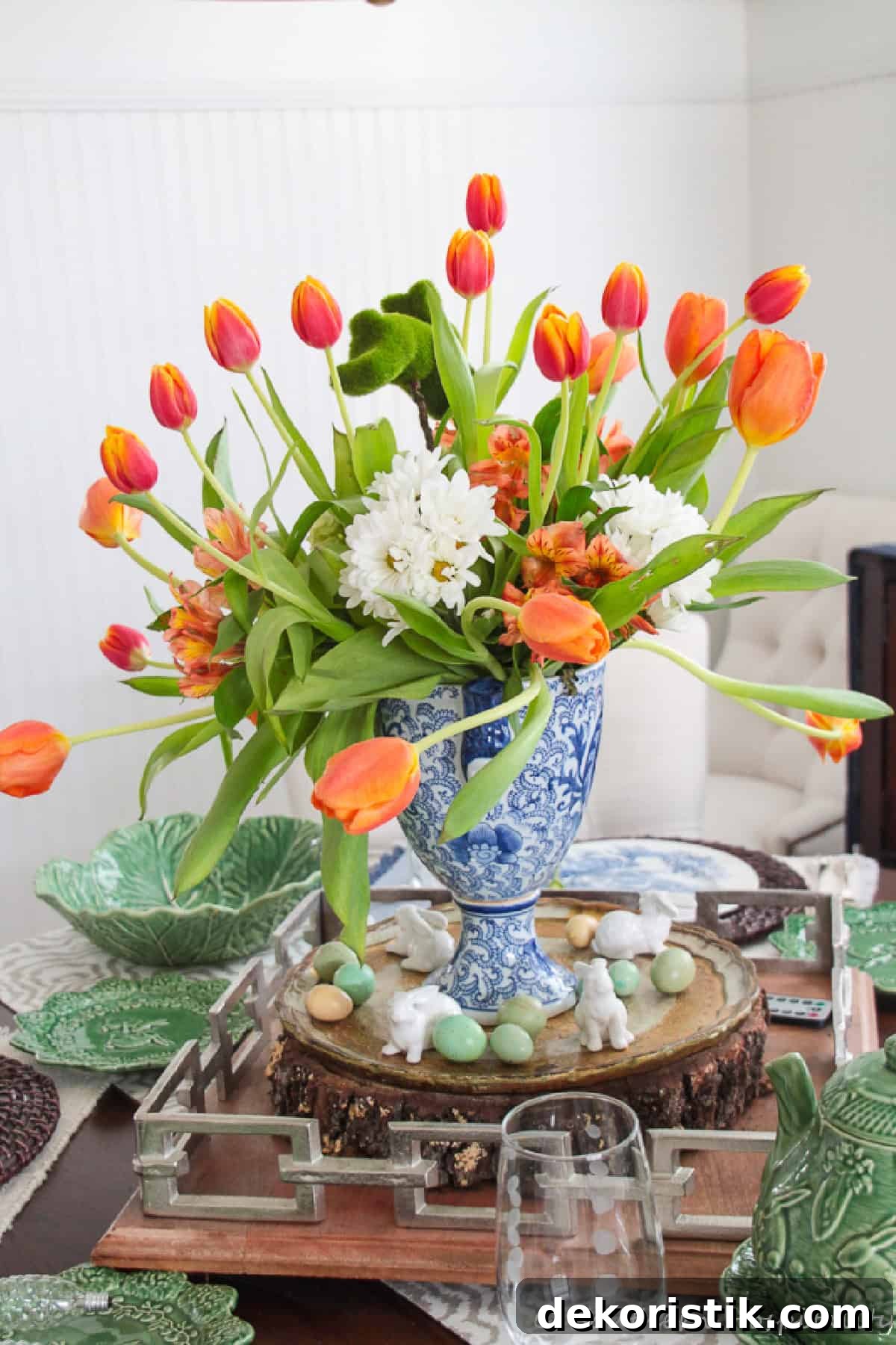 orange tulips in a blue and white vase as part of a dining table spring centerpiece