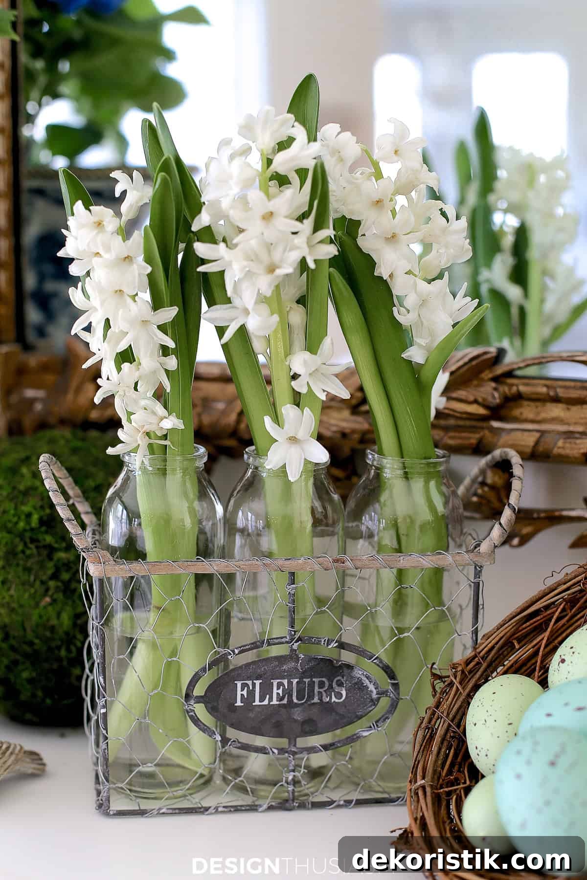 white spring flower sprigs in a trio of glass vases on a mantel