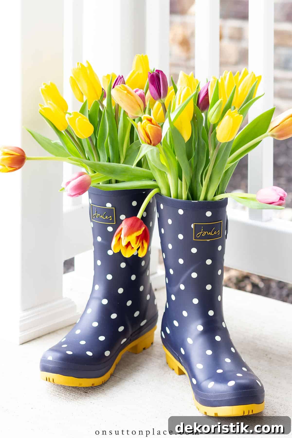 cut daffodils in multiple colors displayed in a pair of blue rain boots