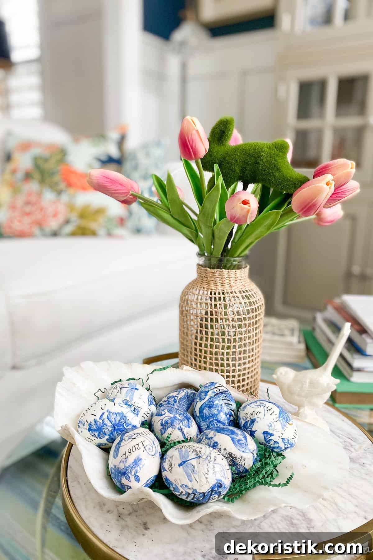 blue and white decoupaged Easter eggs displayed in a clamshell bowl on a coffee table