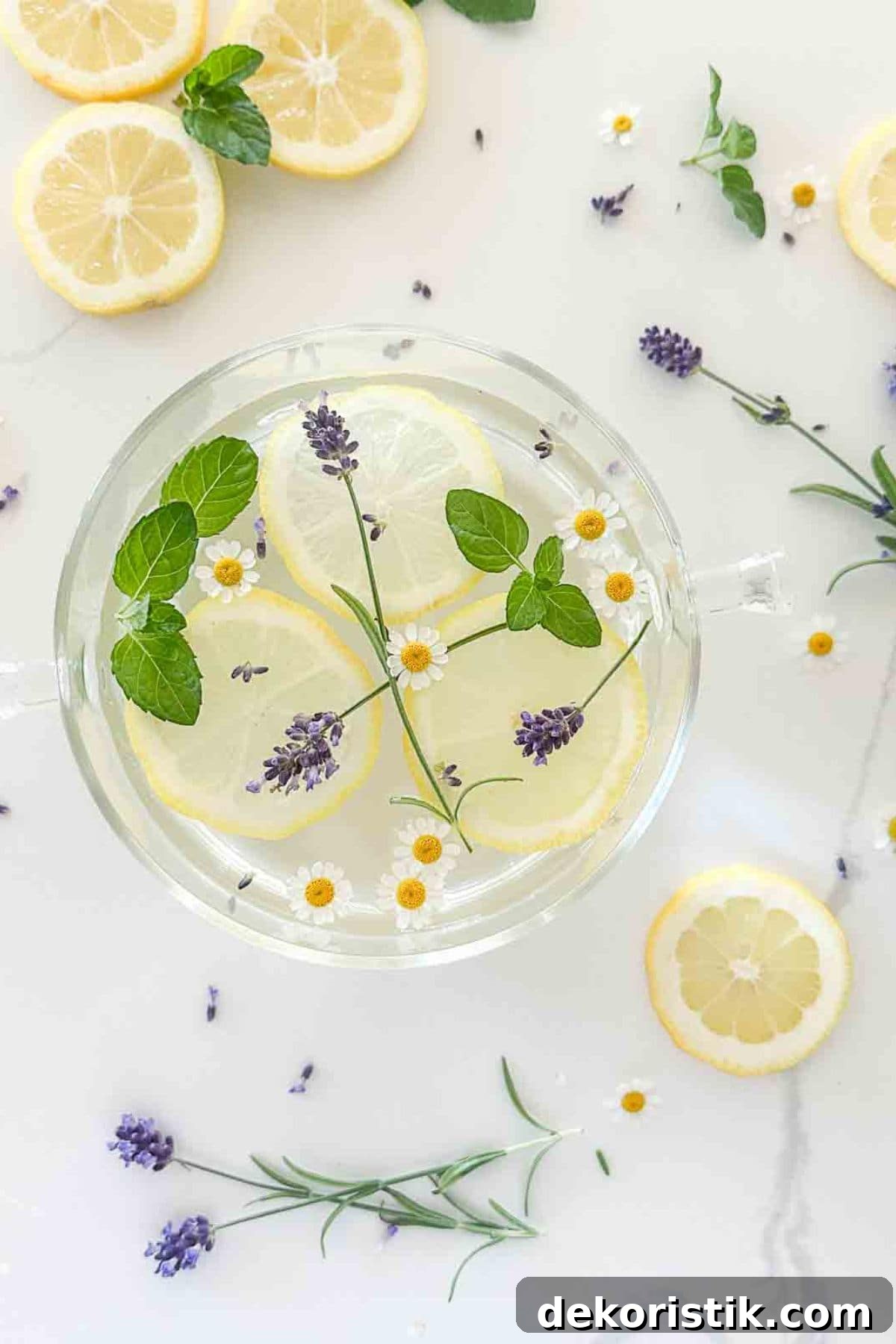 Breezy Summer Decor Ideas and Garden Favorites 6 a clear glass simmer pot filled with clear liquid with daisies, leaves, and purple flowers floating in it