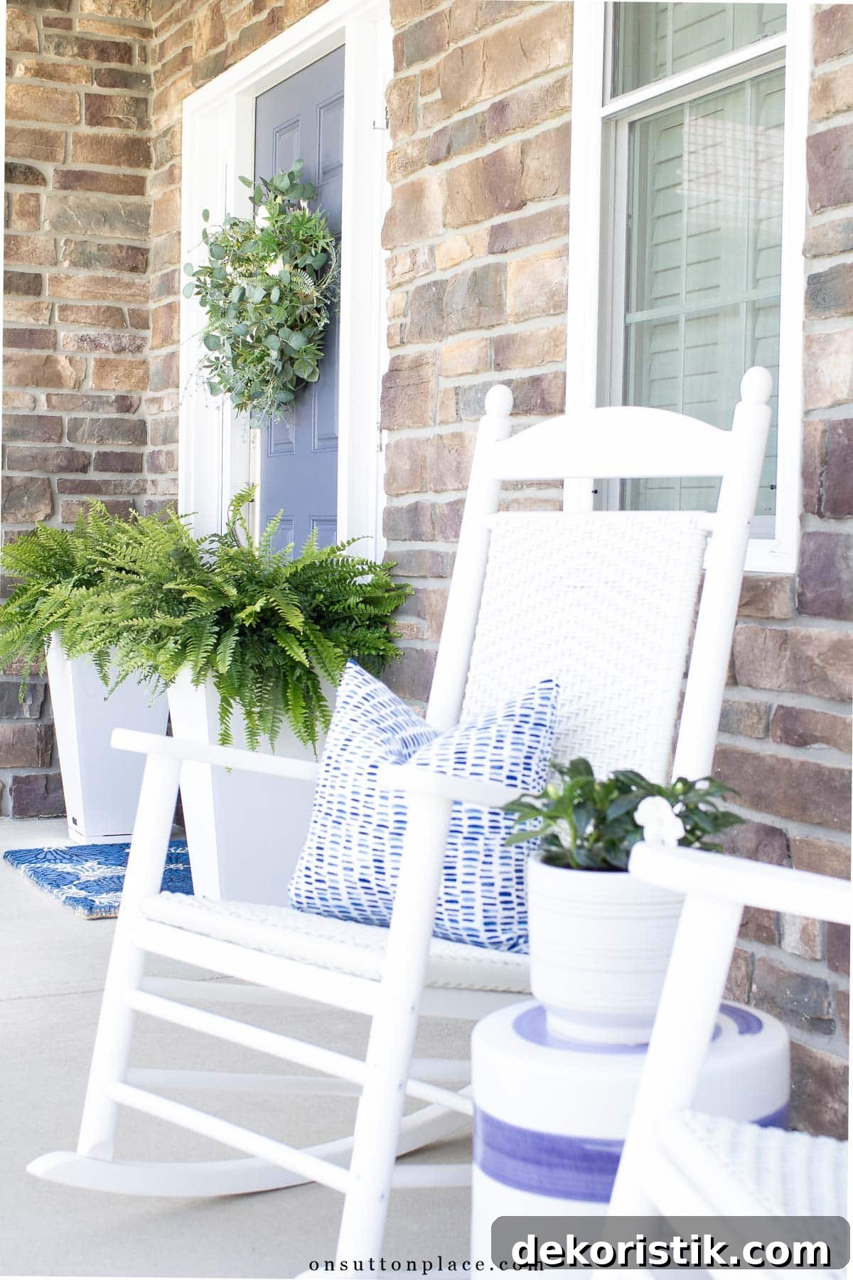 white rocking chair on a front porch with summer decorations