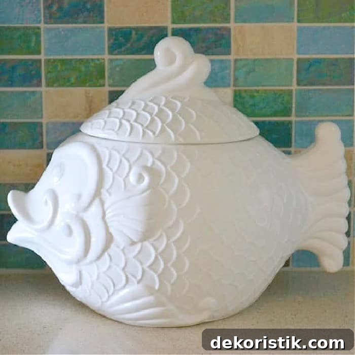 white fish shaped cookie jar in front of blue and aqua glass tile backsplash