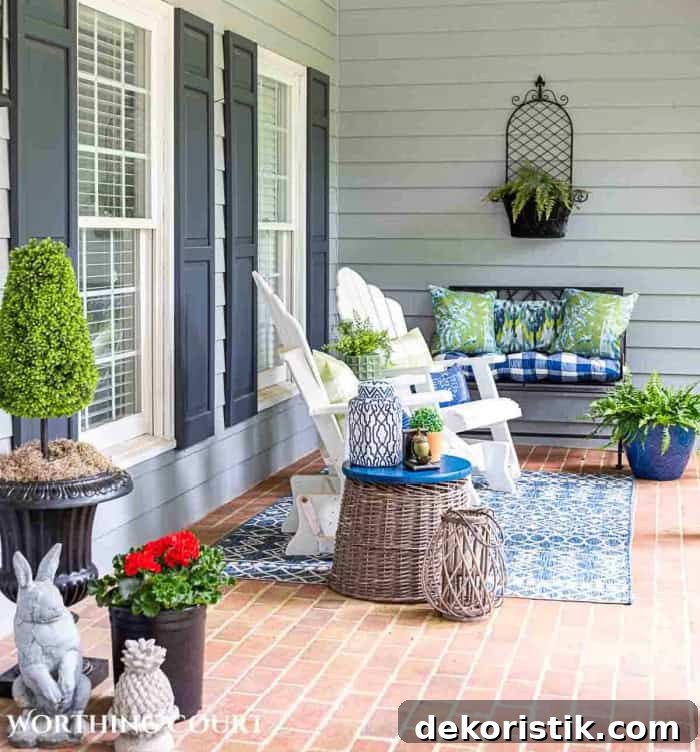 blue and green summer decor on a front porch with white chairs and a brick floor