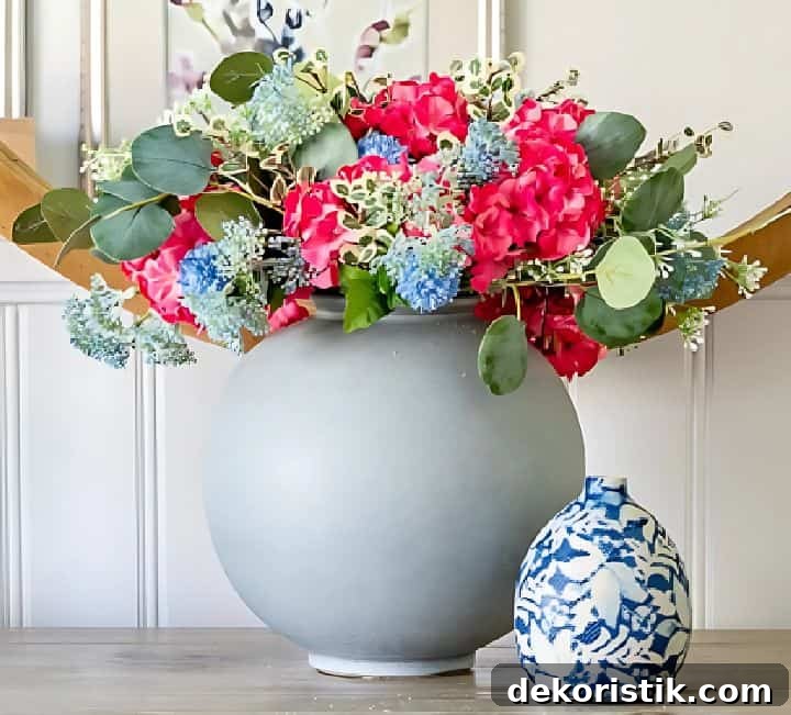 A mix of colorful flowers in a round gray vase
