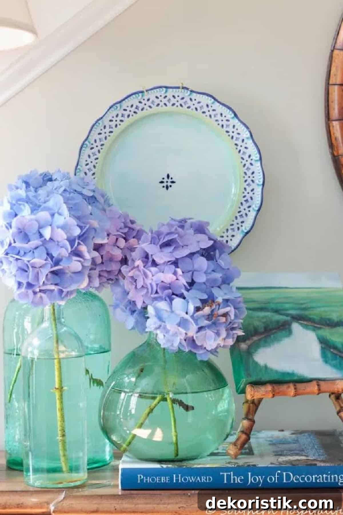 Blue hydrangea blossoms arranged in green glass vases for summer decor